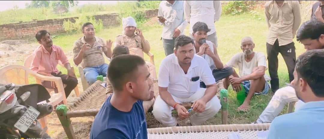 कुर्रियाकलां में खंभा लगाने पहुंचे ग्रामीणों से वार्ता करते जेई। संवाद