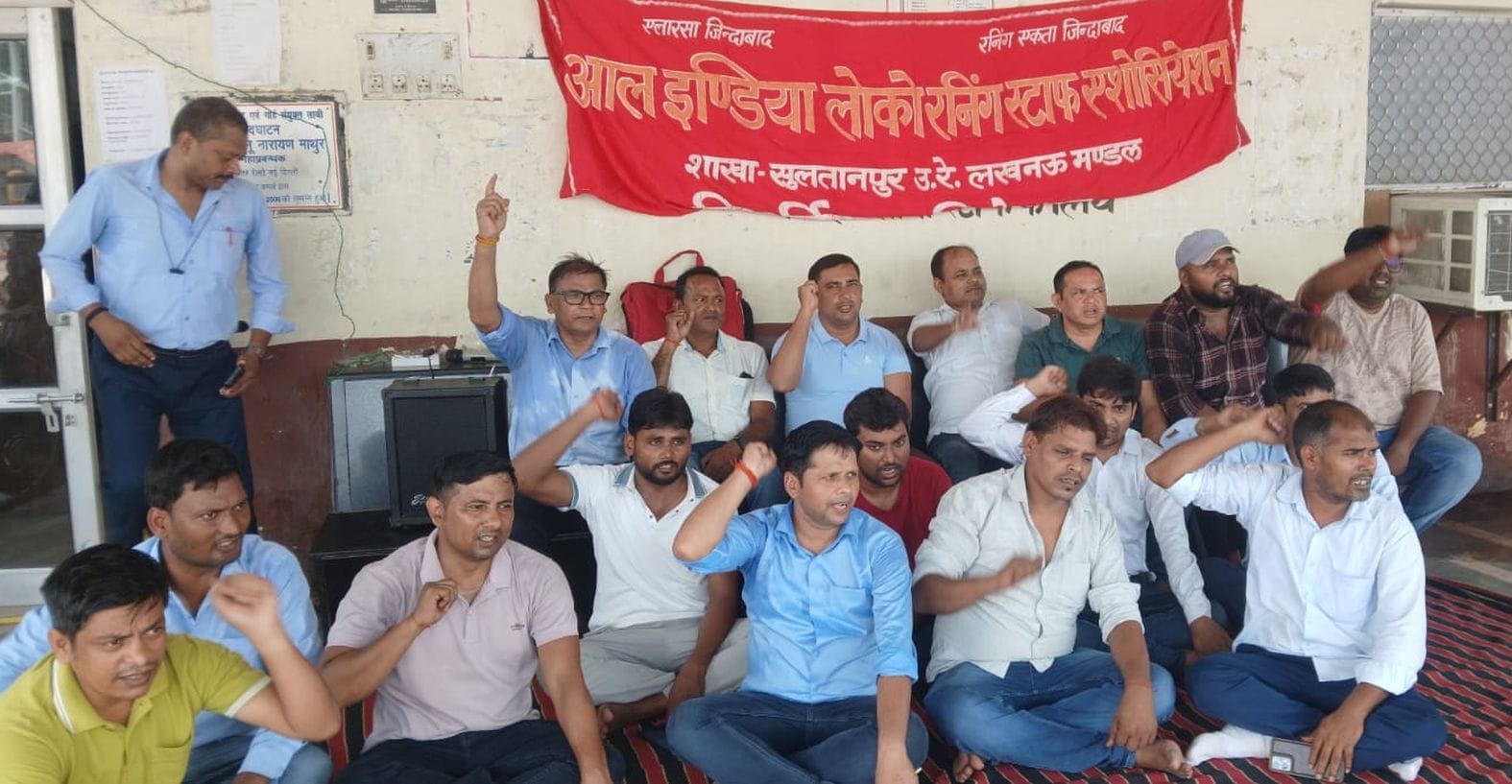  रेलवे स्टेशन के प्लेटफॉर्म नंबर एक पर प्रदर्शन करते कर्मचारी। संवाद