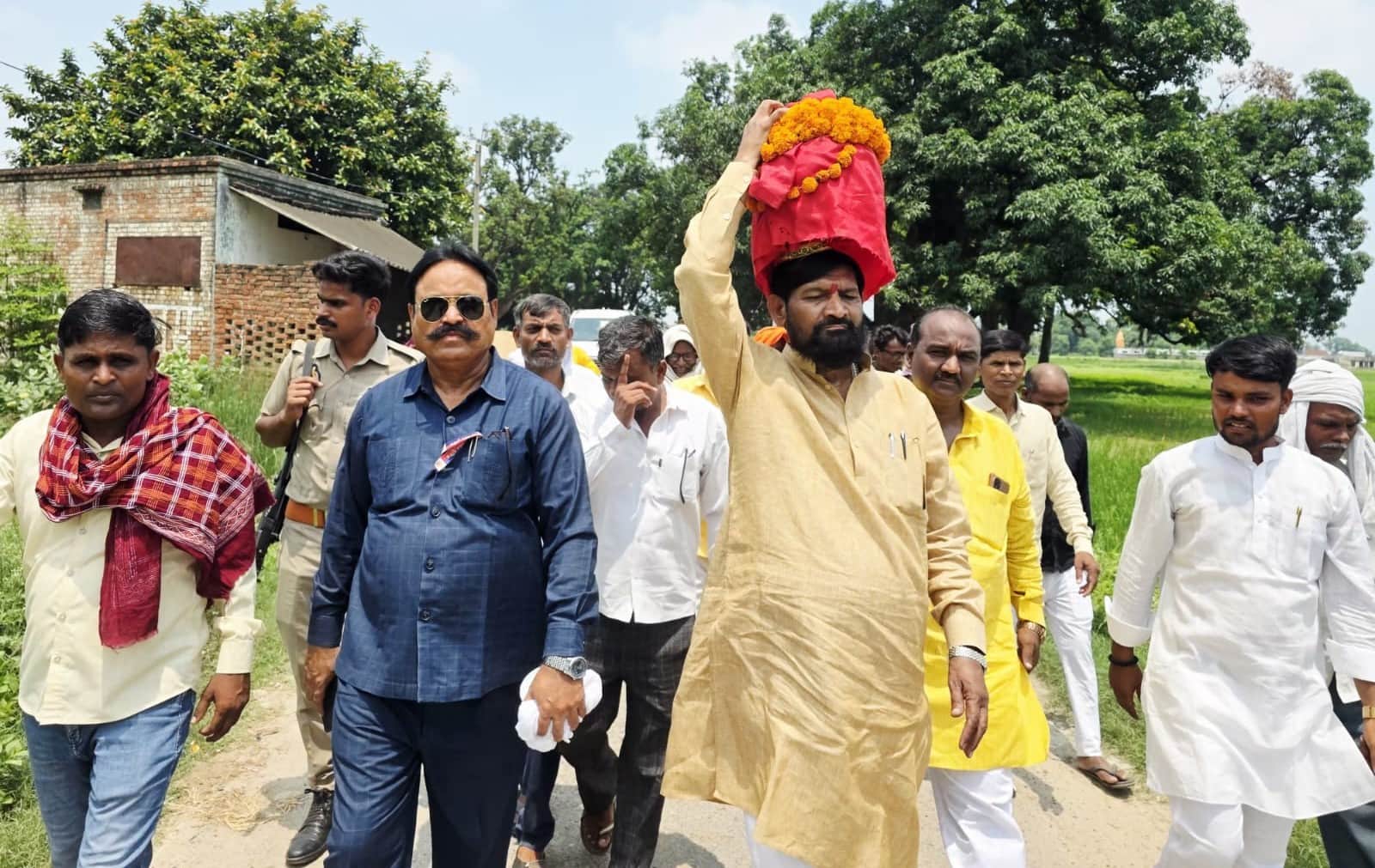सर पर कलश रखकर जाते औराई विधायक दिनानाथ भाष्कर। स्रोत संगठन