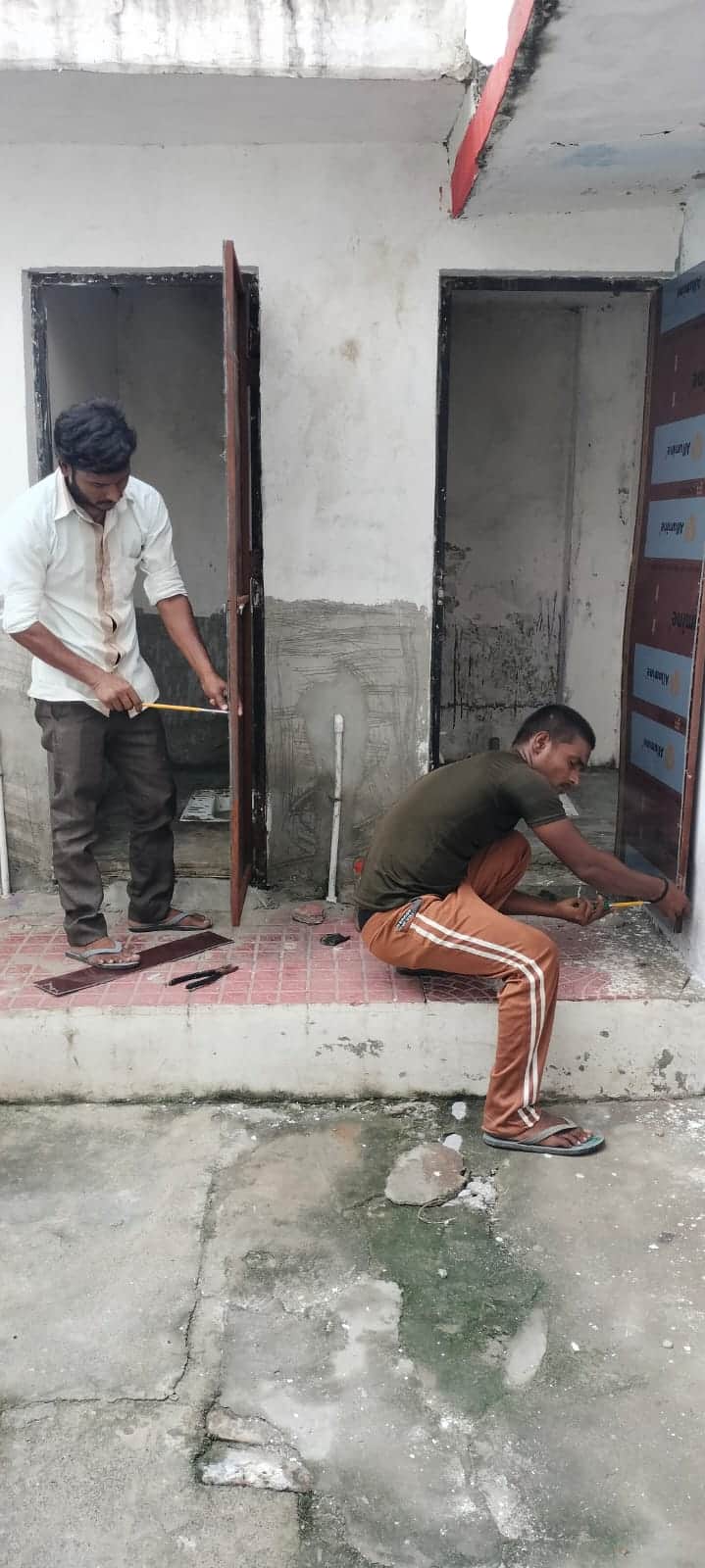 शाहजहांपुर में रोटी गोदाम स्कूल में दरवाजों को सही करते कर्मचारी। संवाद