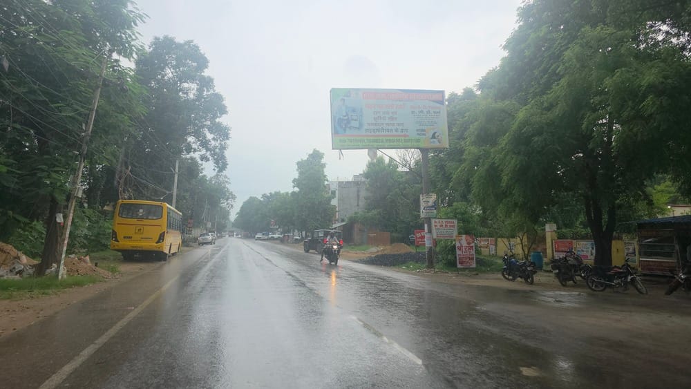 शहर के बसखारी मार्ग पर बृहस्पतिवार दोपहर करीब दो बजे बारिश के दौरान आवागमन करते वाहन सवार।संवाद