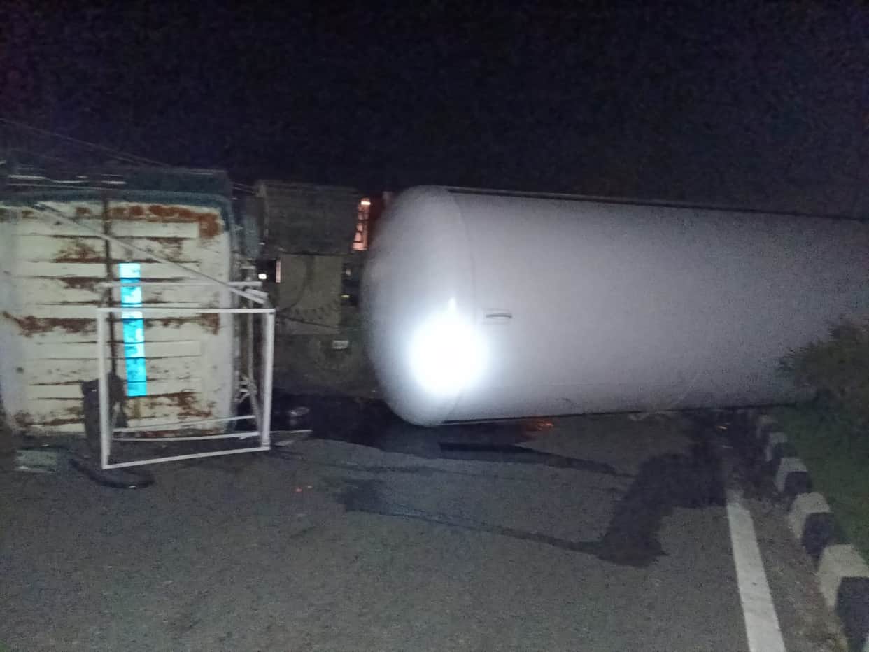 Gas tanker overturns; driver injured.