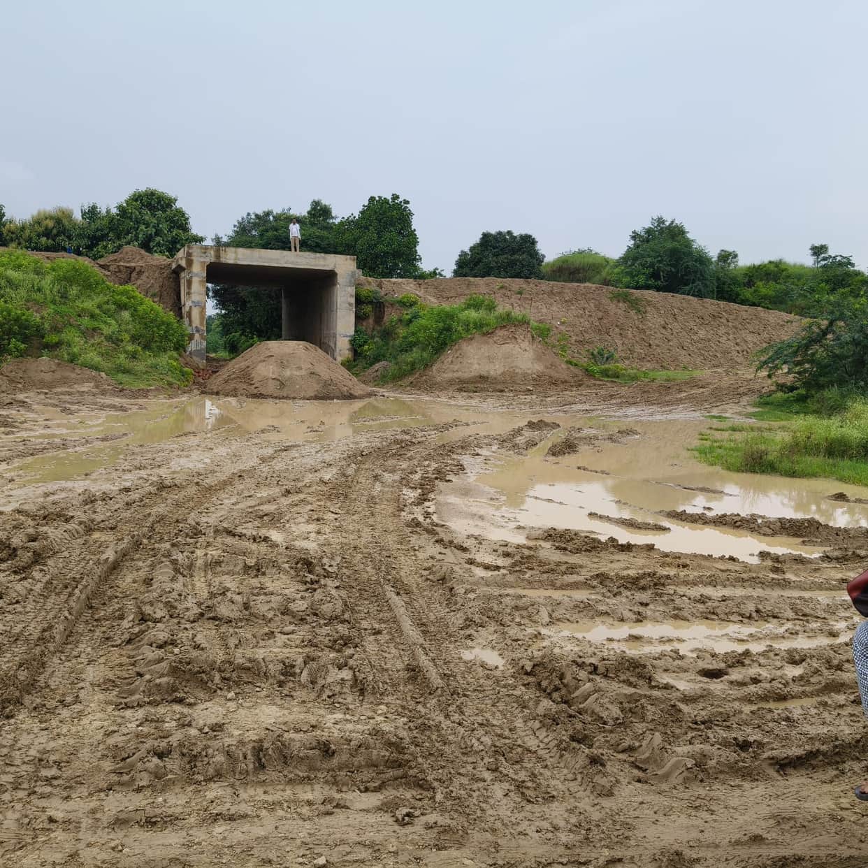 Rain reopens the wounds of the unpaved road; children's path mired in mud