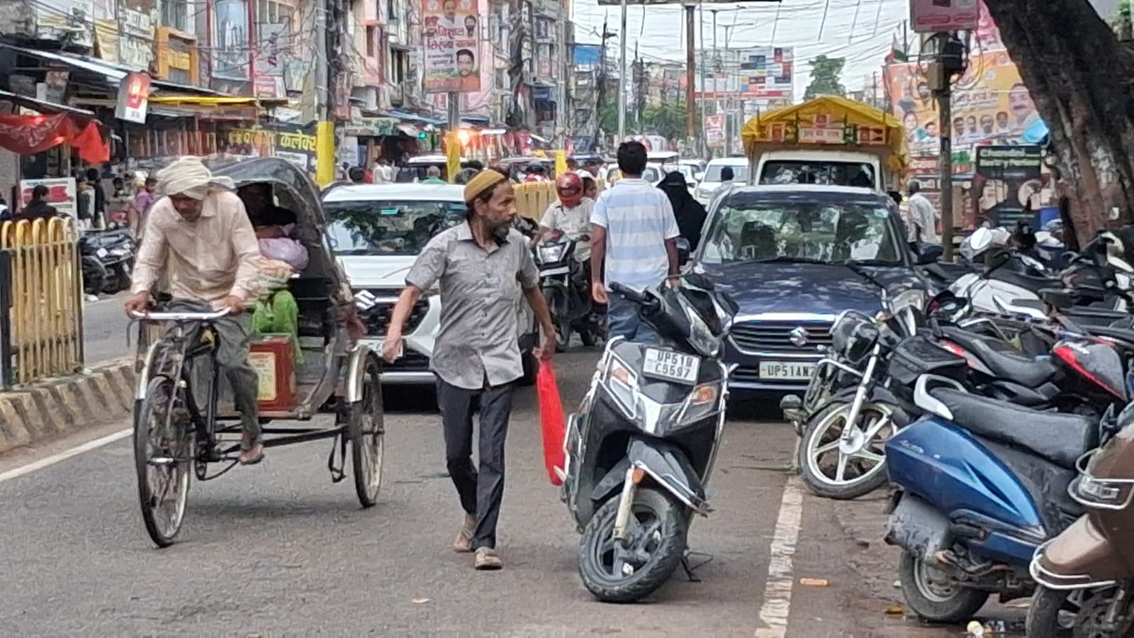 गांधीनगर हनुमान गढ़ी के पास बेतरतीब खड़ी गाड़ियों के बीच से बहाल हो रहा आवागमन।