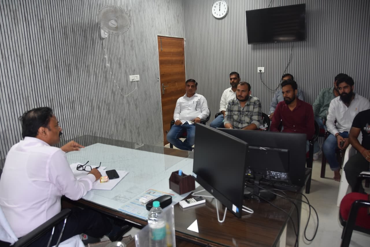 मीटिंग के दौरान बातचीत करते जिला नगरायुक्त प्रदीप अहलावत। स्रोत : प्रशासन