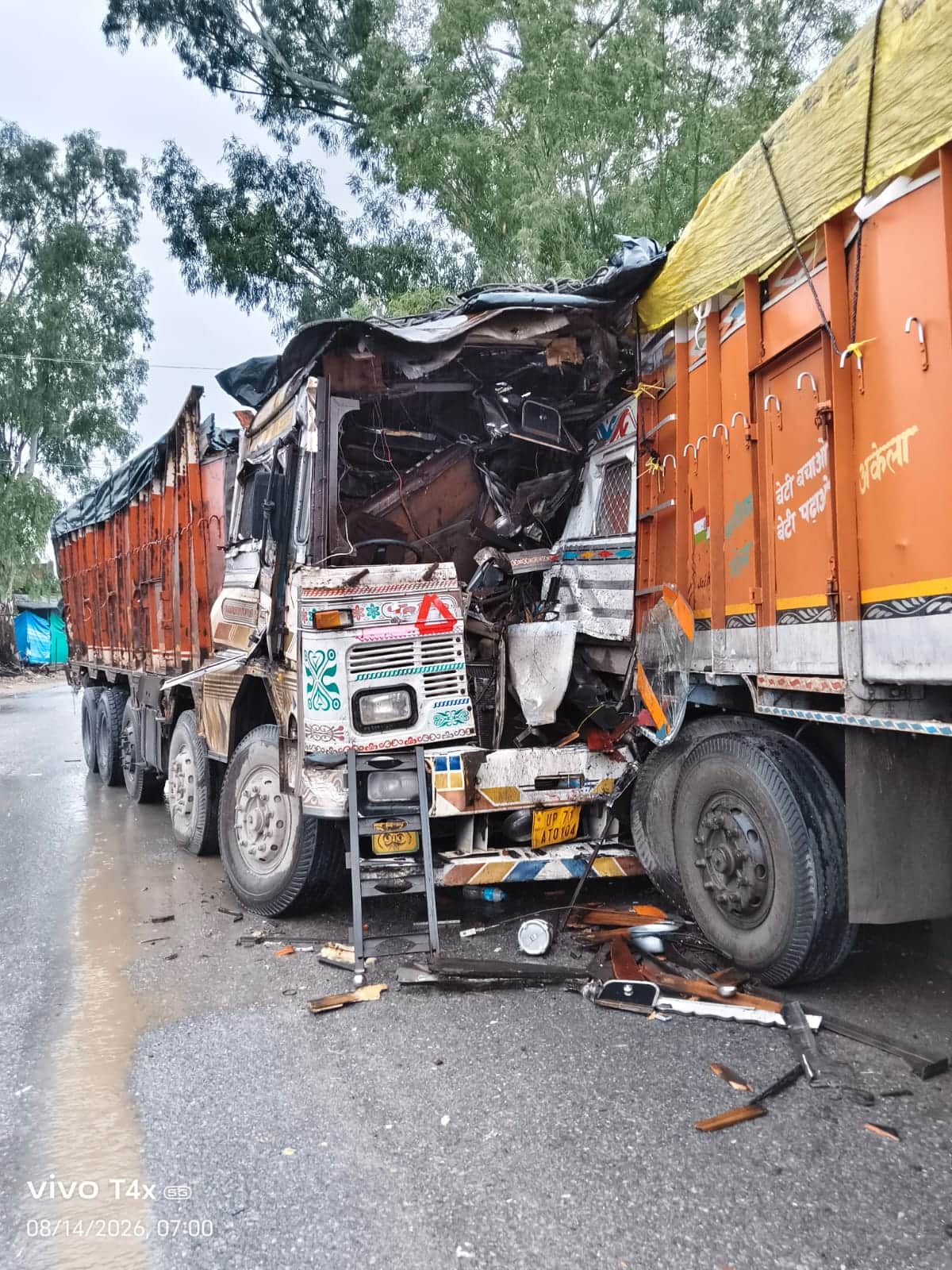 Two trucks collide head-on while overtaking; driver injured.