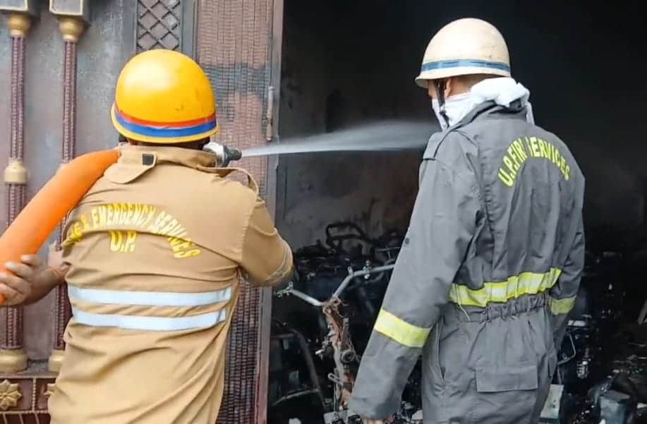 शामली के चौधरी चरण सिंह कॉलोनी में शोरूम में लगी आगको बुझाते दमकलकर्मी। स्रोत वीडियोग्रेब
