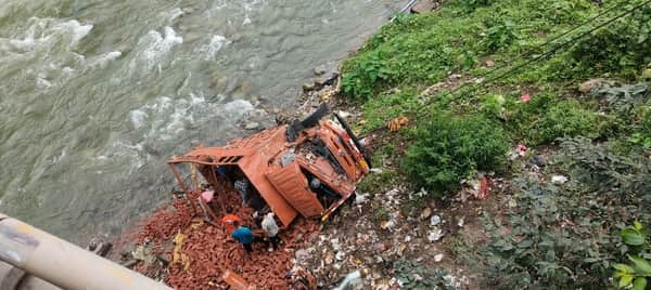 Brick-laden Canter crashes through bridge railing and falls into ravine.