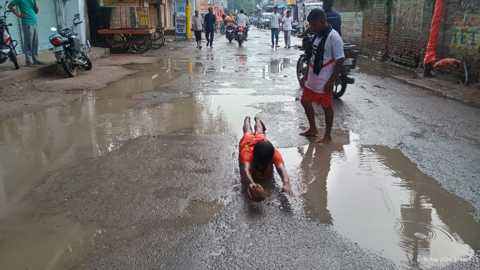बीमार मां मीना देवी के ठीक होने की मनौती पर शहर के महुआग में जगह-जगह धंसी सड़क के बीच  जमा बारि