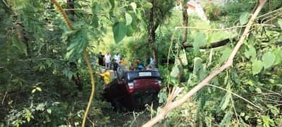 Car rolls into 15-foot-deep gorge at sharp turn; family safe.