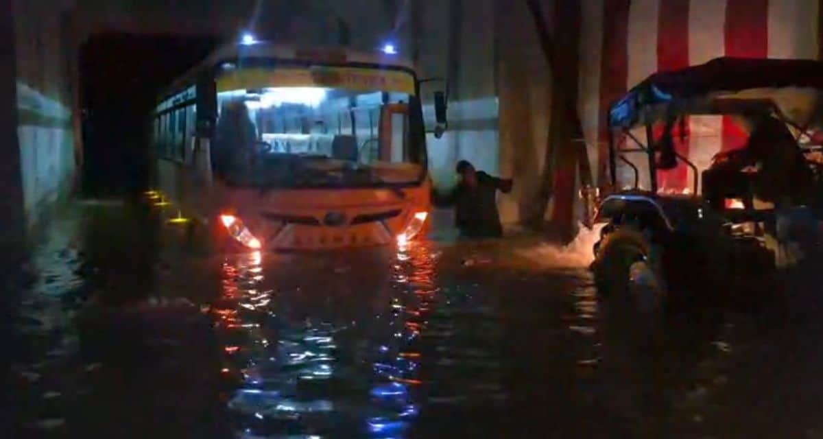 Bus stuck in waterlogged underpass; panic among passengers.