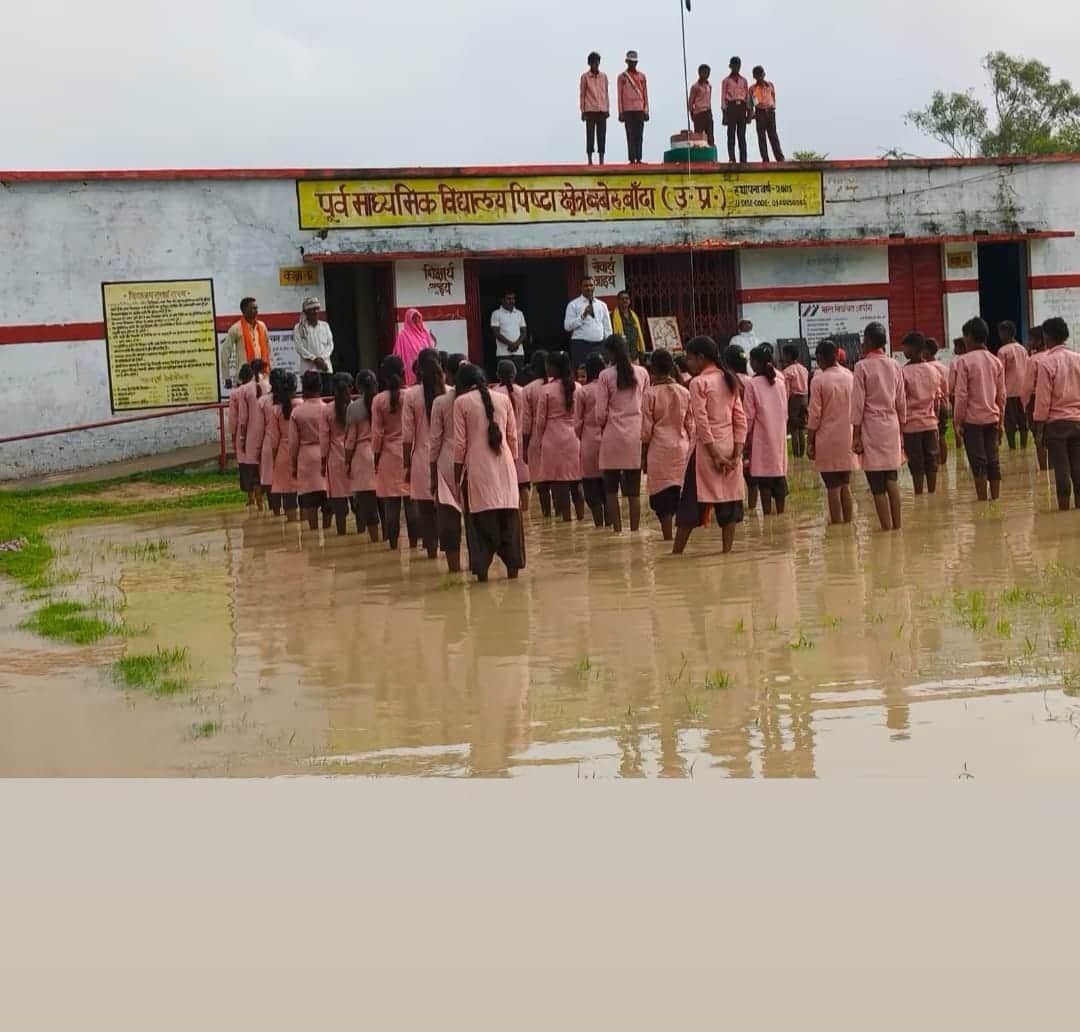 Children hoisted the flag while standing in dirty water.