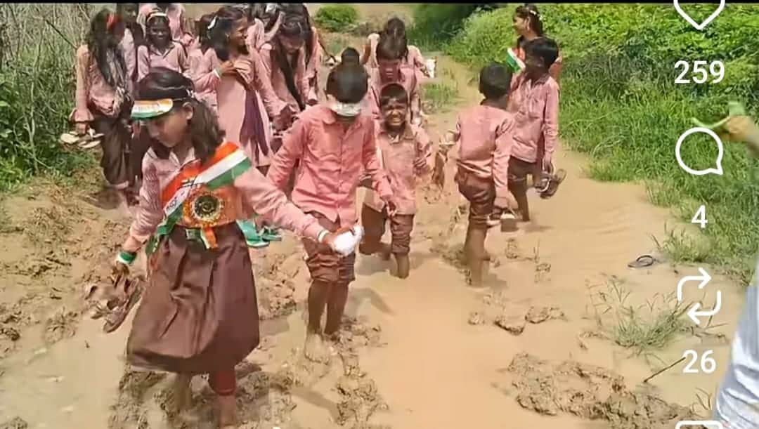 Children wading through mud reveal the reality of the road.