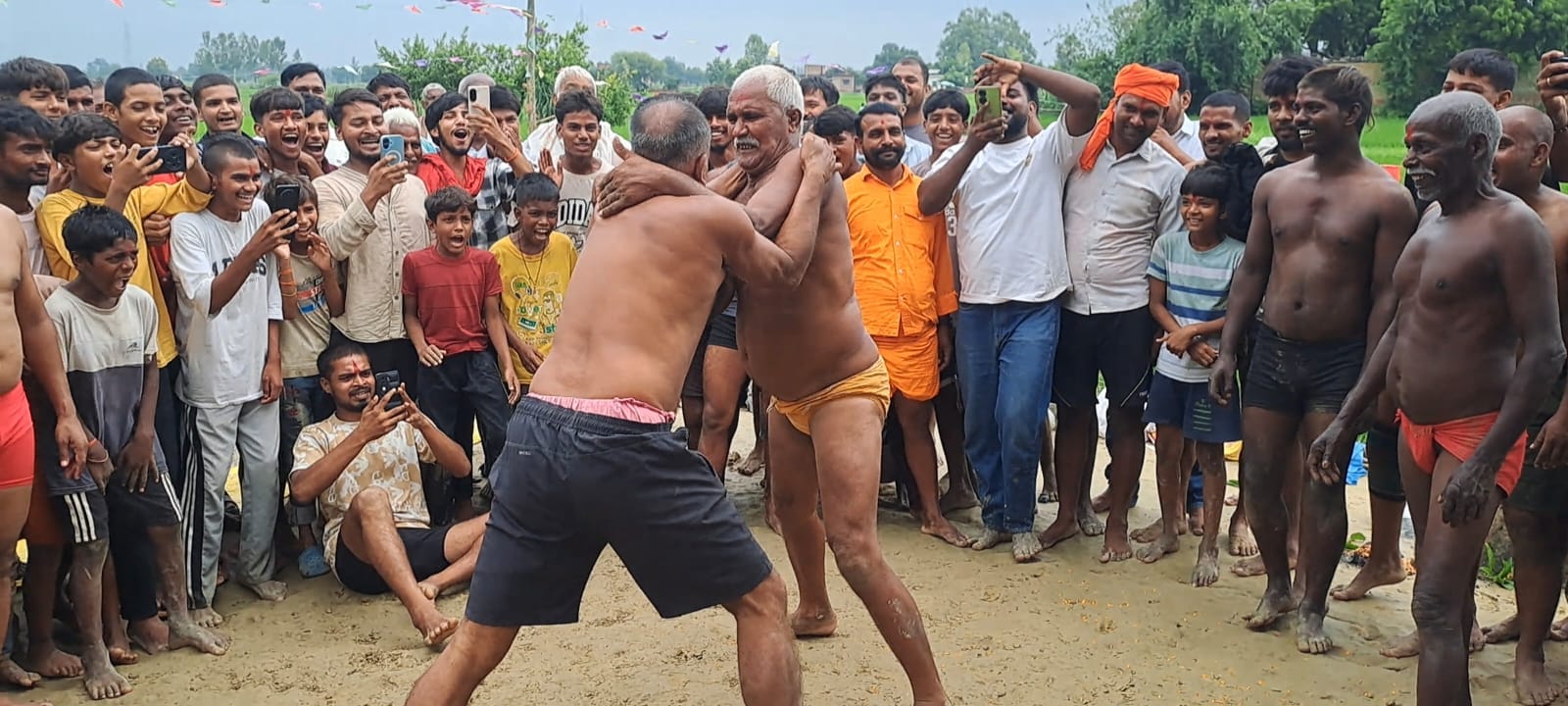 नाग पंचमी पर खूंटा बहोरवा में सजी पारंपरिक कुश्ती के दौरान दांव-पेंच का प्रदर्शन करते पहलवान।सं