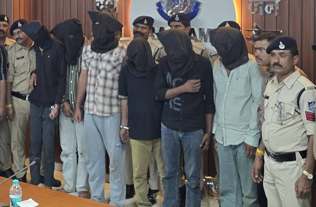 पुलिस गिरफ्त में नकाब पहने आरोपी।