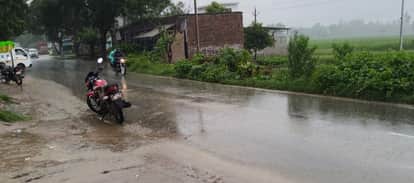  सोमवार को हुई बारिश के बीच निकलते लोग। संवाद