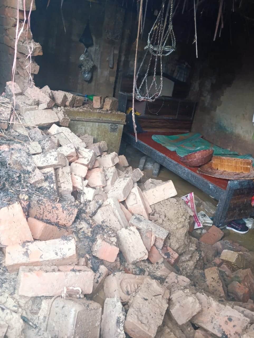 Wall of a mud house collapses; family has a narrow escape.