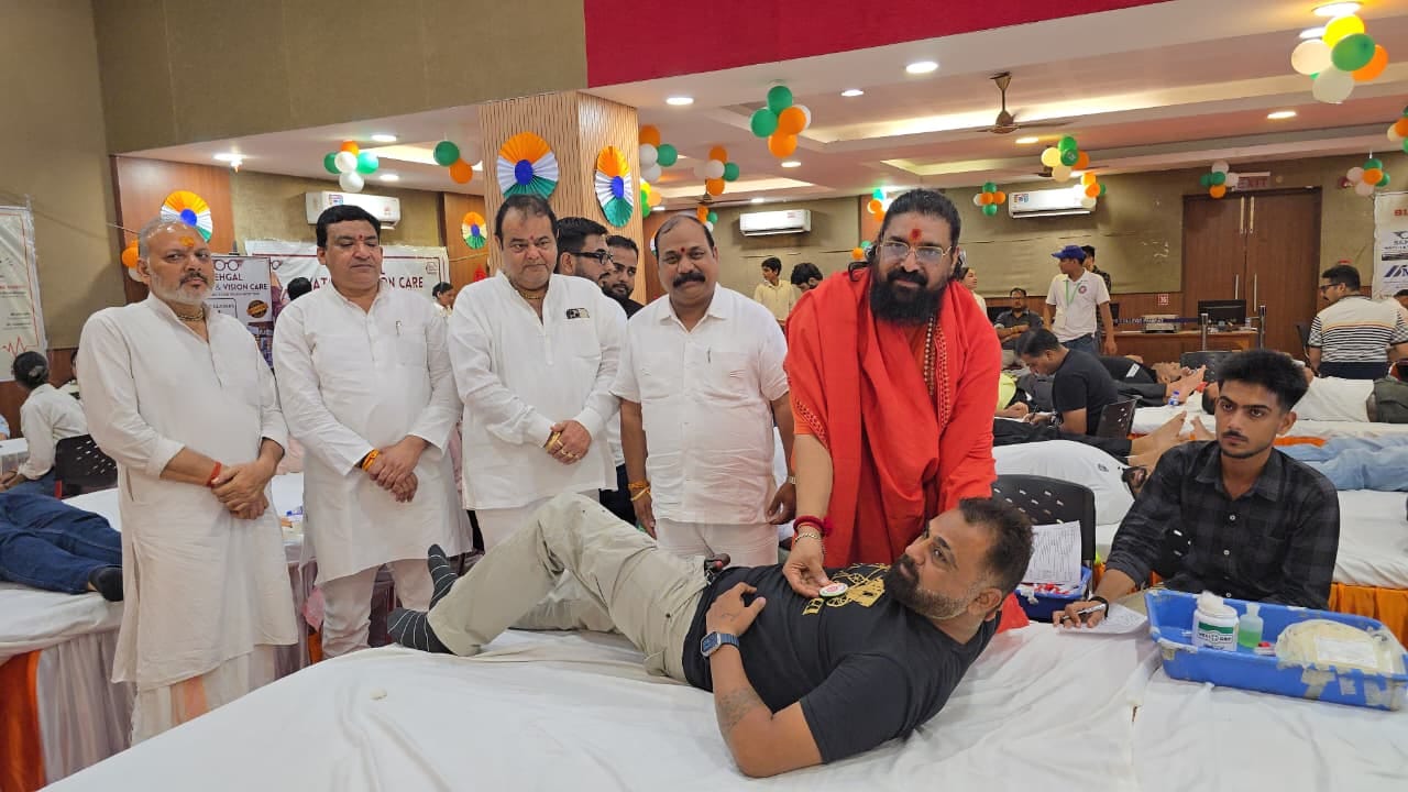 रक्तदाता को बैज लगाते अरुण दास महाराज। संवाद