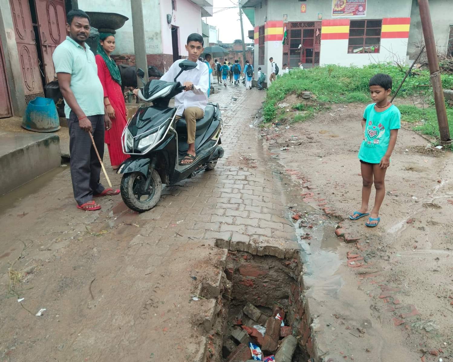 बनियाठेर के गांव अकरौली में भूमिगत केबल डालने के लिए खोदे गए गड्ढे को देखते लोग - संवाद