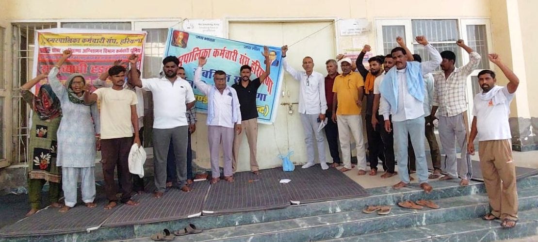 फोटो 18जेएनडी13-नगर पालिका मुख्य गेट पर ताला जड़ नारेबाजी करते हुए सफाई एवं अग्निशमन कर्मचारी। 