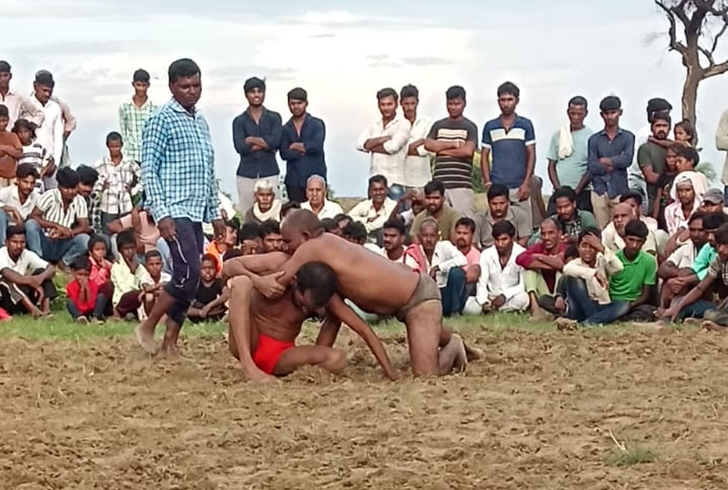 हाजीपुर गांव स्थित श्रीपारेश्वर मंदिर परिसर में आयोजित दंगल में कुश्ती लड़ते पहलवान।
