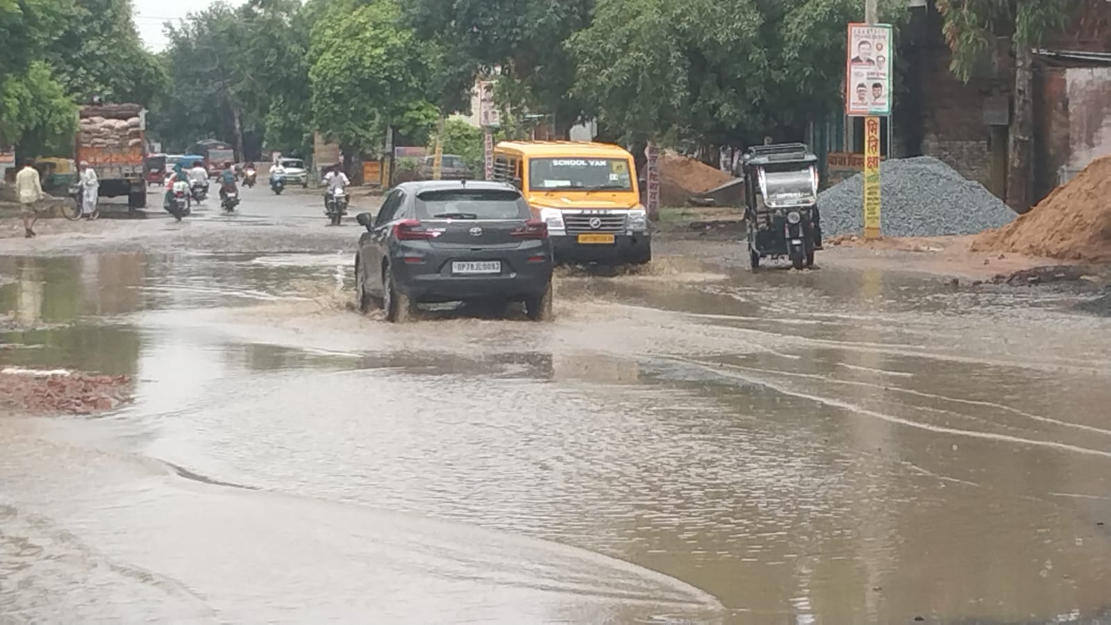 शहर के दिबियापुर रोड पर जलभराव के बीच निकलते वाहन। संवाद