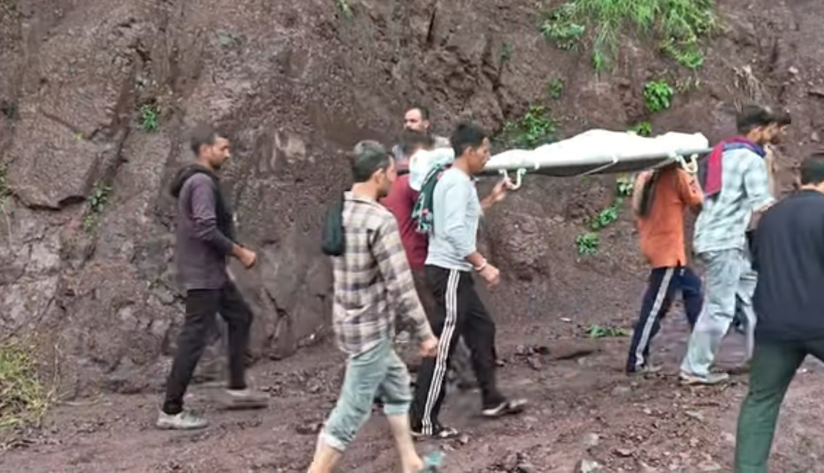 शवों को खाई से निकालकर बाहर लाते ग्रामीण।