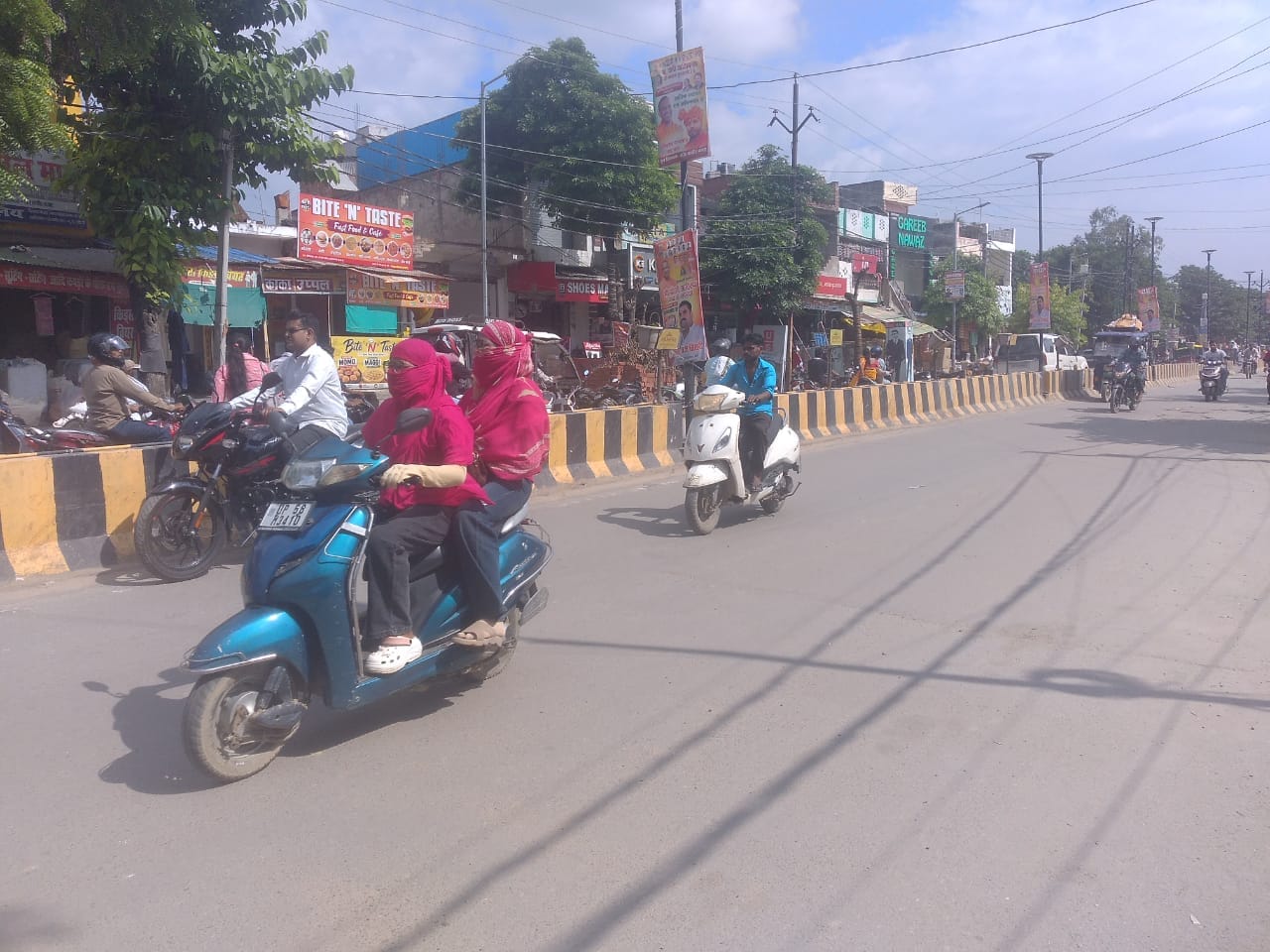 उमस के चलते सिर ढक कर जातीं युवतियां। संवाद