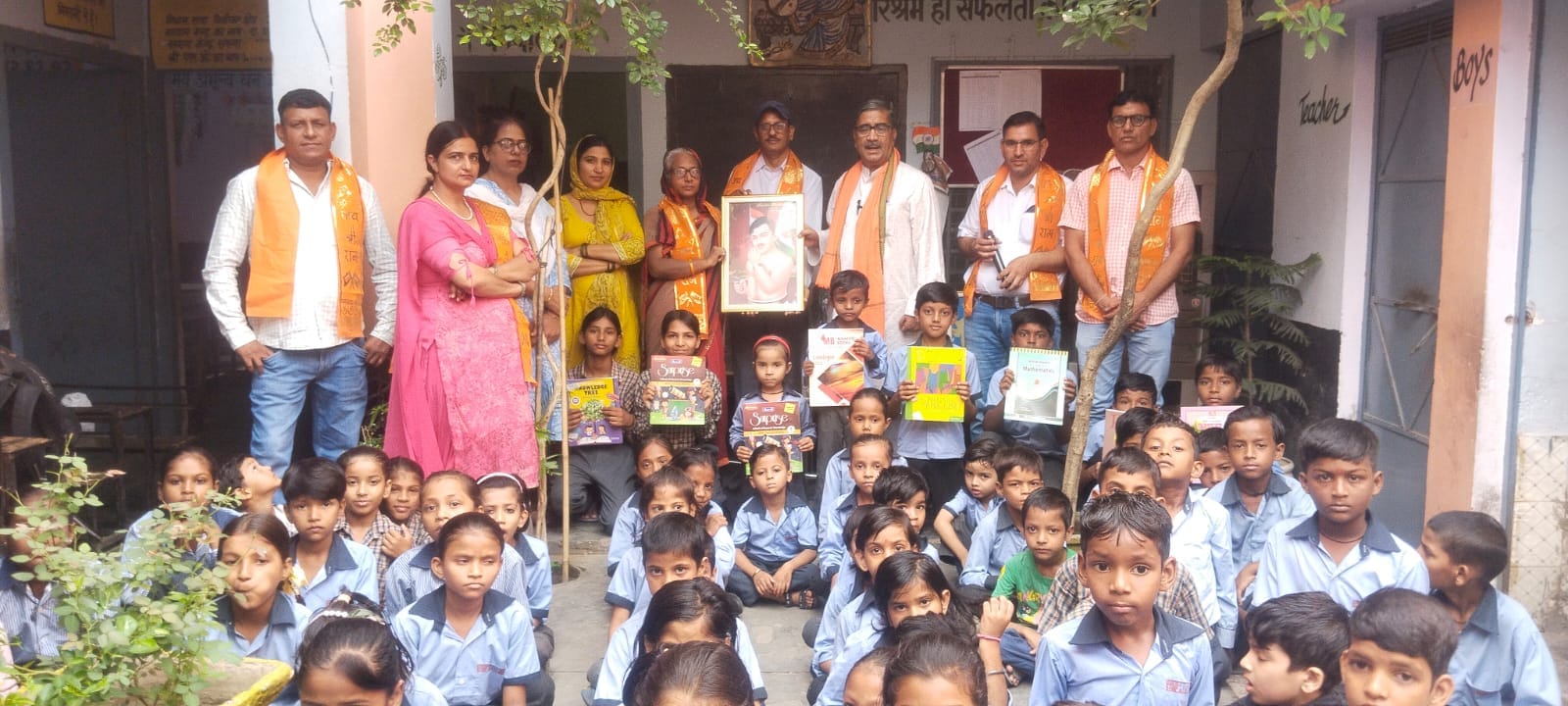 विद्यार्थियों को पाठ्य सामग्री भेंट करते युवा दल के सदस्य। स्त्रोत: स्कूल