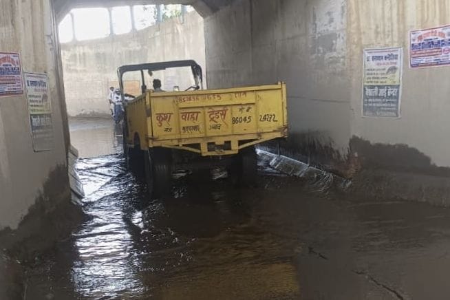 फोटो-4-महमदाबाद मार्ग के रेलवे अंडरपास में भरे पानी के बीच निकलती ट्रैक्टर ट्राली। संवाद