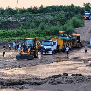 No bridge over the Boli River; people crossing while risking their lives; truck gets stuck.