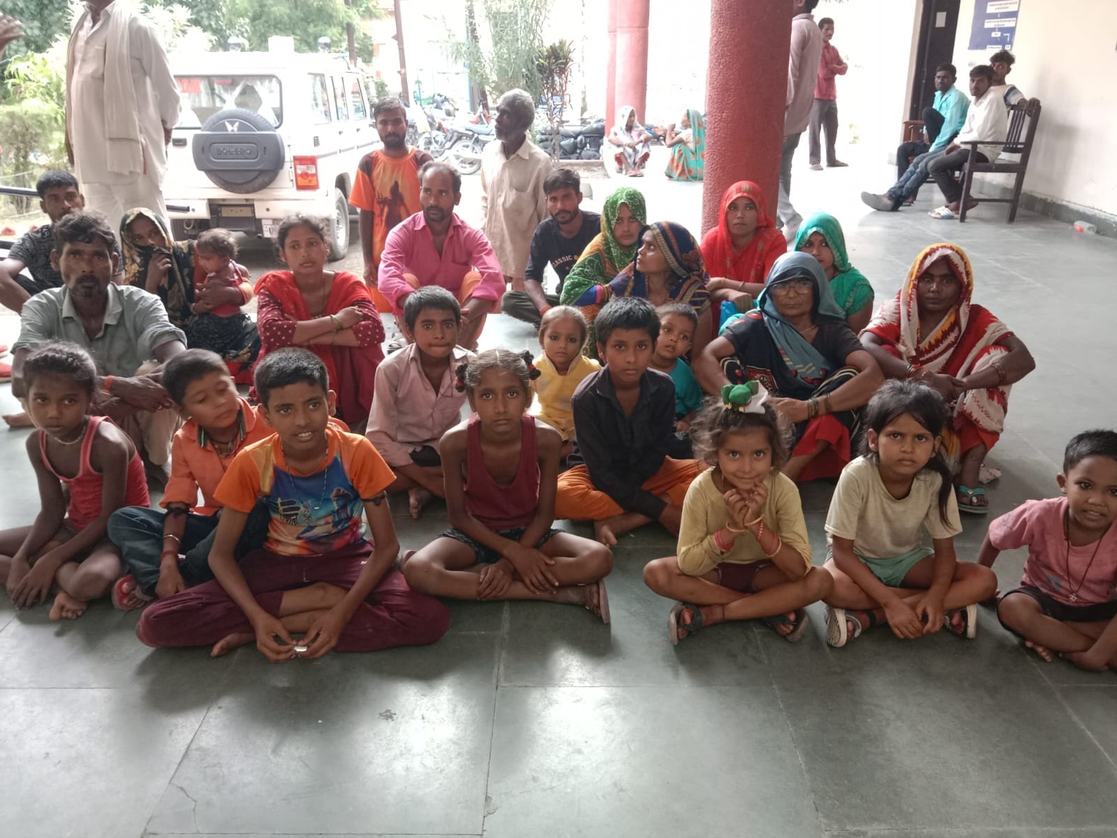 पलिया तहसील में बैठे बेदखली की नोटिस पाए परिवार व उनके बच्चे।संवाद