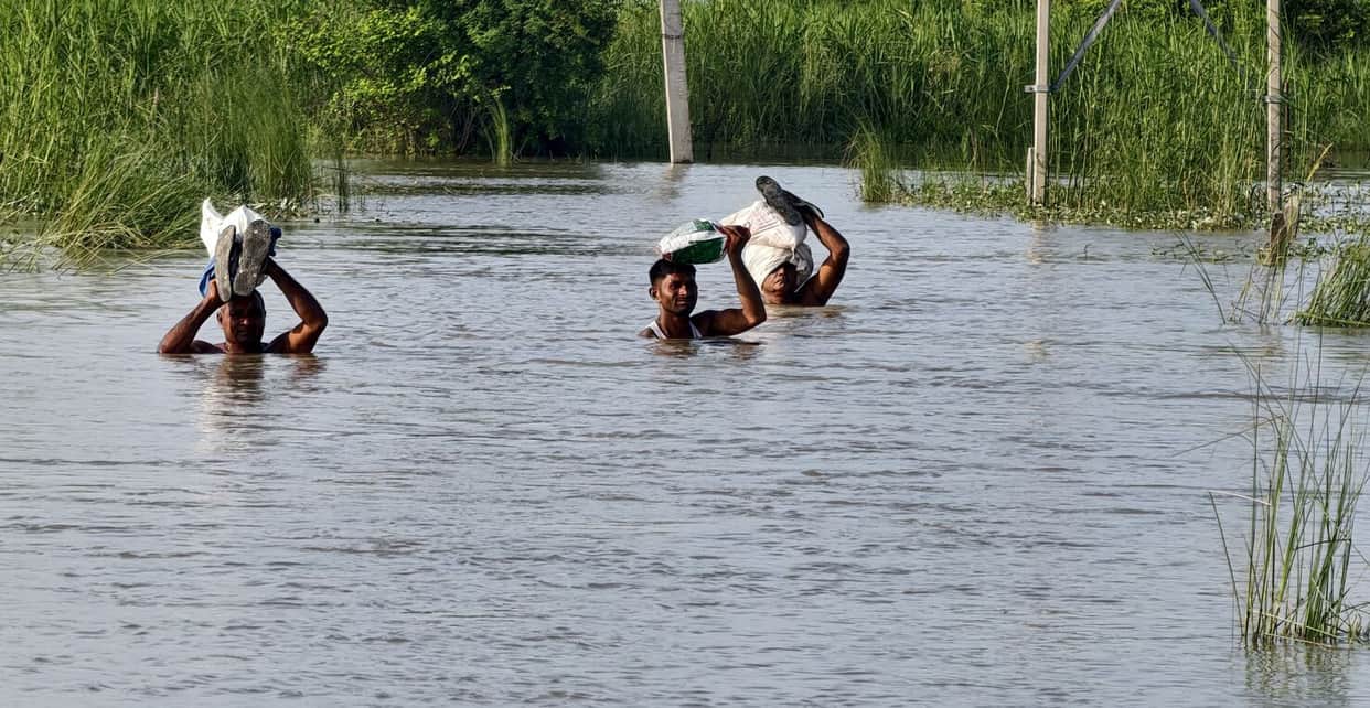 800 villagers rely on a single boat; forced to wade through shoulder deep water to reach home.