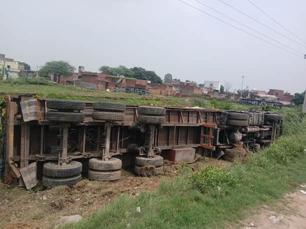 Container overturns while trying to avoid a motorcyclist.