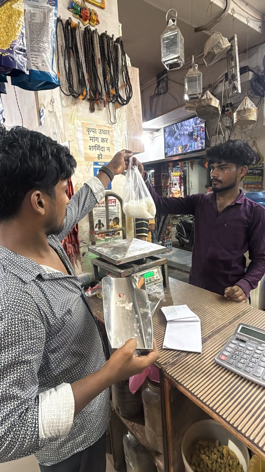 शहर में स्तिथ दुकान पर चीनी की खरीददारी करते ग्राहक। संवाद