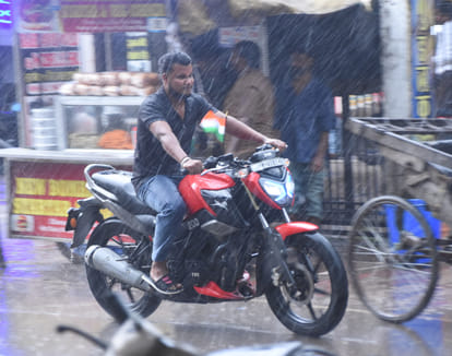 बहराइच में शुक्रवार की शाम को बारिश में भीगते हुए जाता युवक।