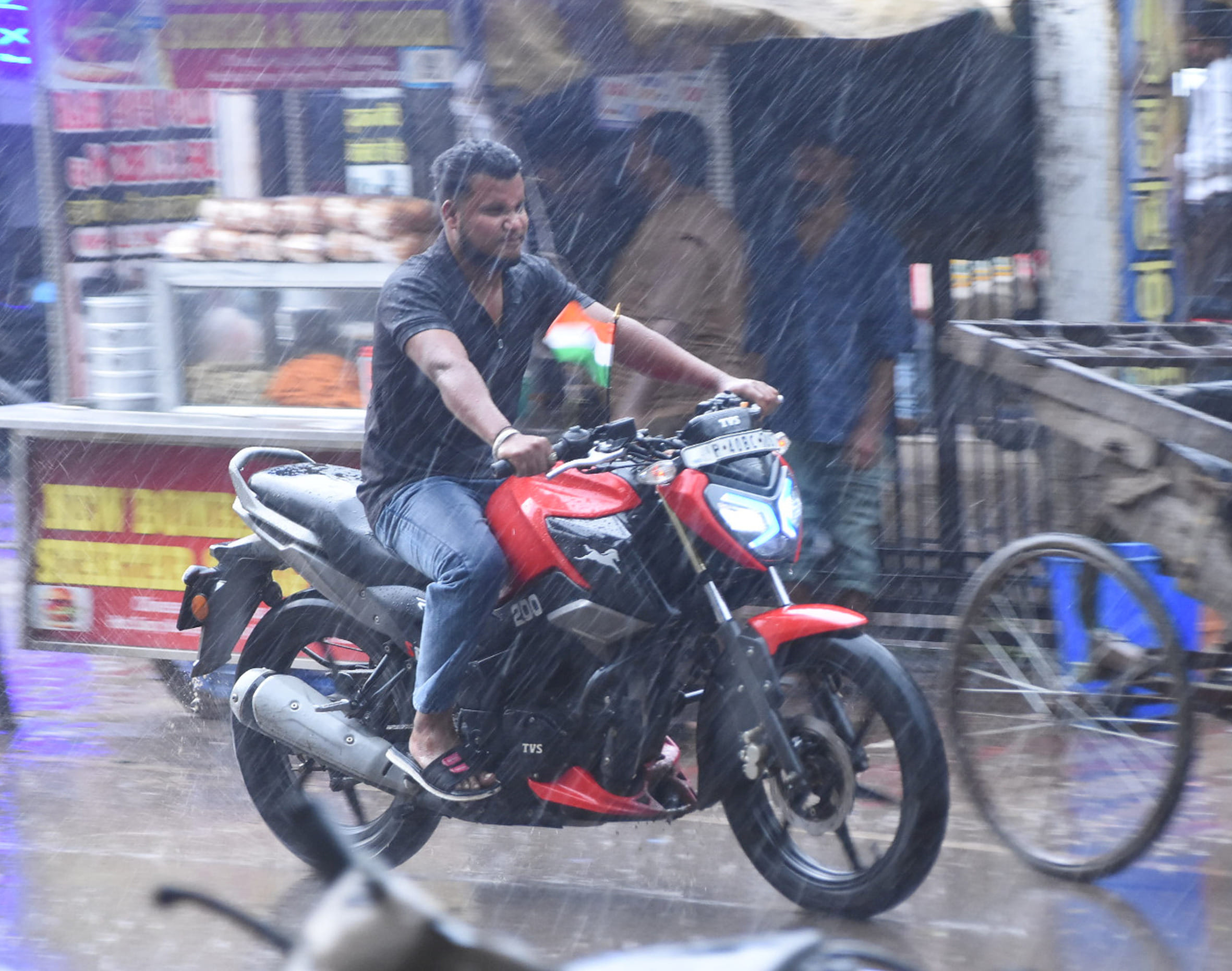 बहराइच में शुक्रवार की शाम को बारिश में भीगते हुए जाता युवक।