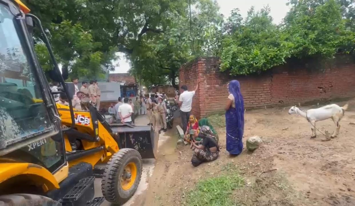 Women sat down in front of the JCB; the team that had arrived to clear the path returned.