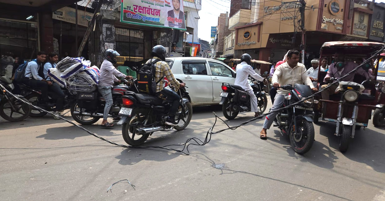 Power line snaps and falls onto the road; motorists have a narrow escape.