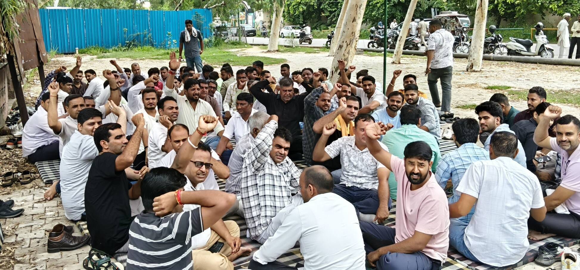 लघु सचिवालय के मुख्य द्वार पर धरने पर बैठे पटवारी व कानूनगो। 