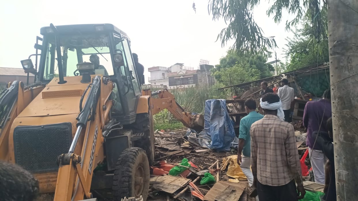 Bulldozer used against pond encroachment; encroached land cleared.