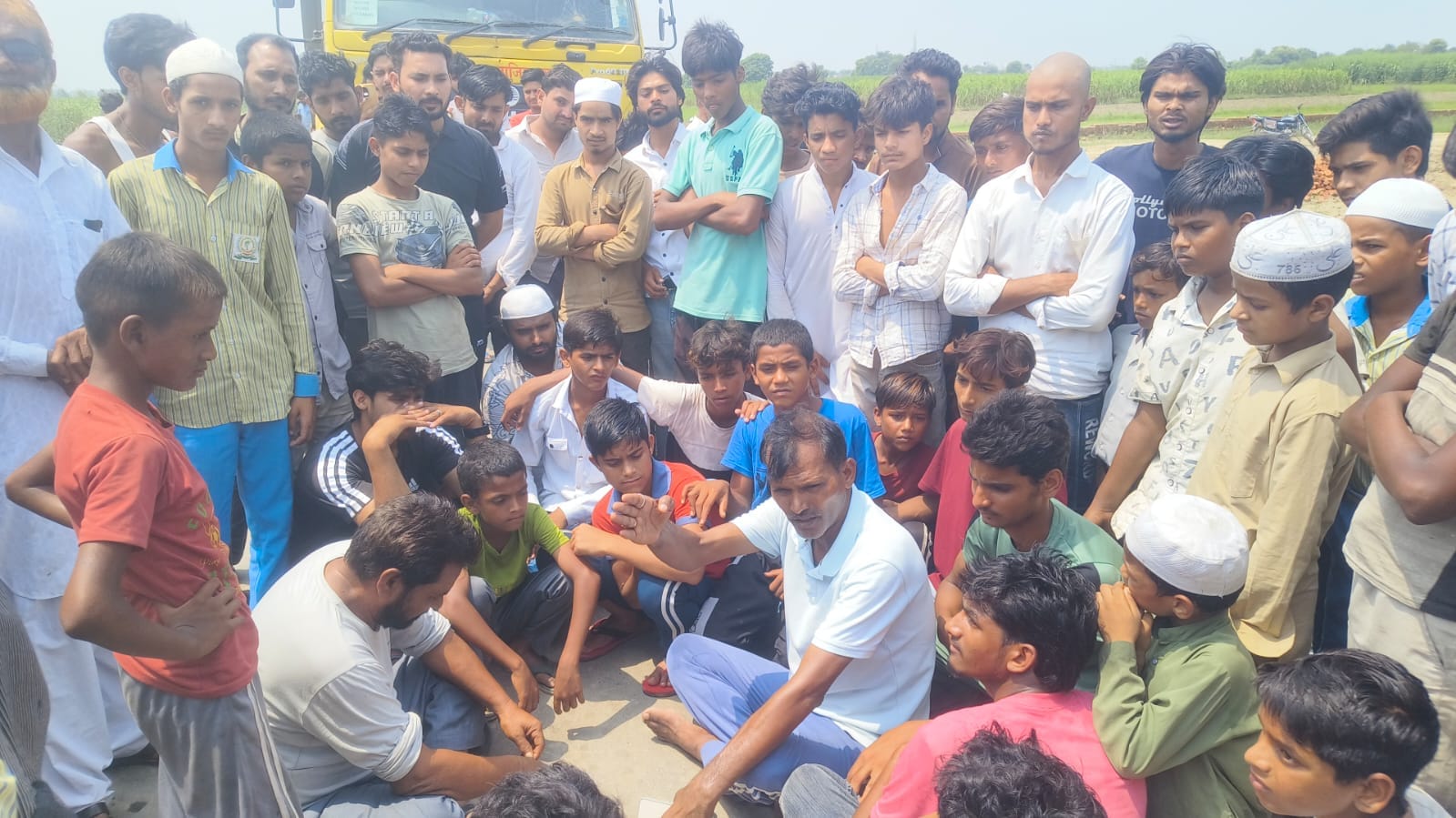 डासना में डंपर की टक्कर से हुई व्यक्ति की मौत के बाद हंगामा करते लोग। संवाद