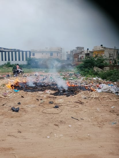 बस स्टैंड के पीछे स्थित एकत्रित कचरे में लगाई गई आग।