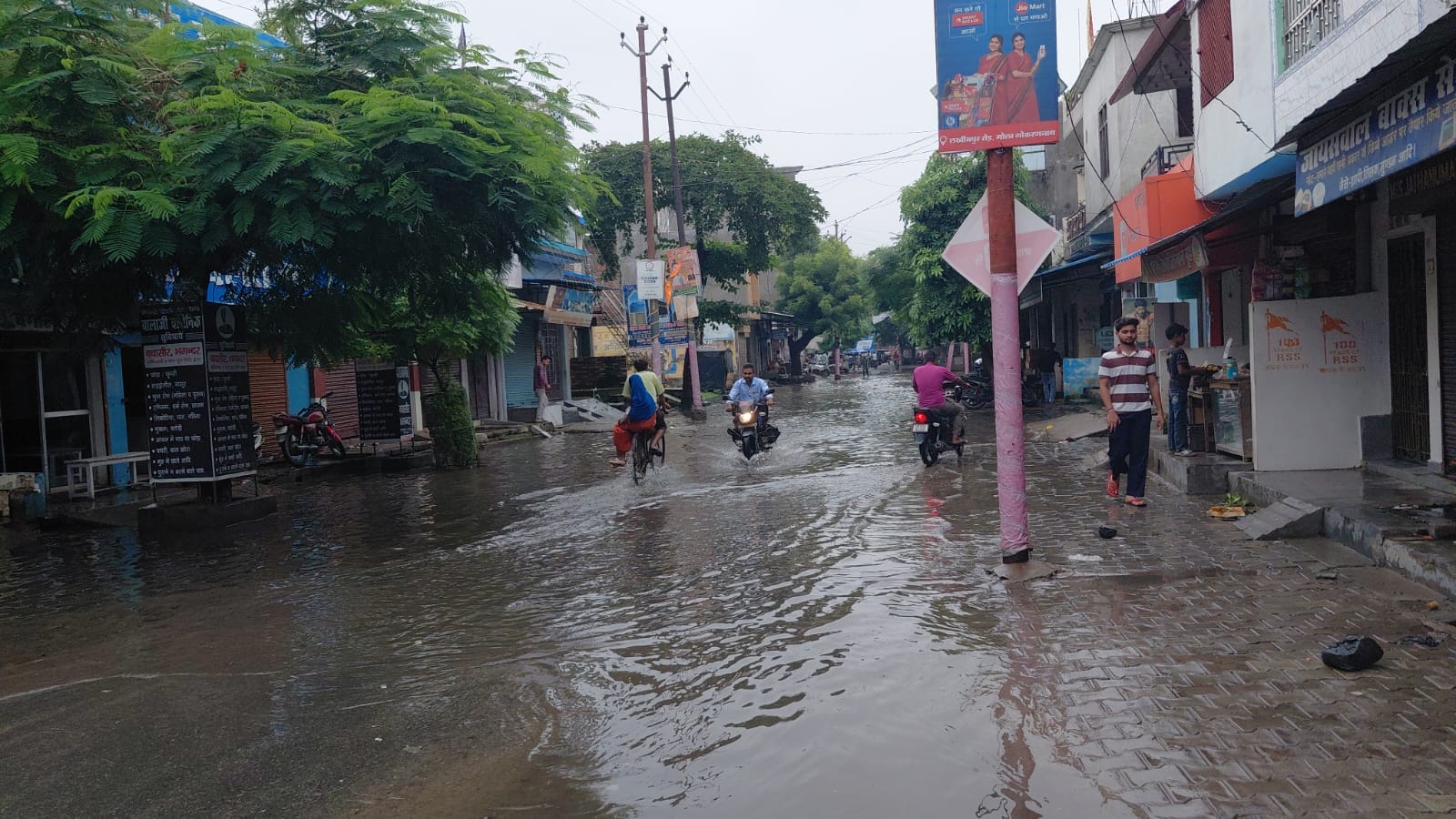 गोला में मिल डायवर्जन मार्ग पर जल भराव से निकालते श्रद्धालु। संवाद