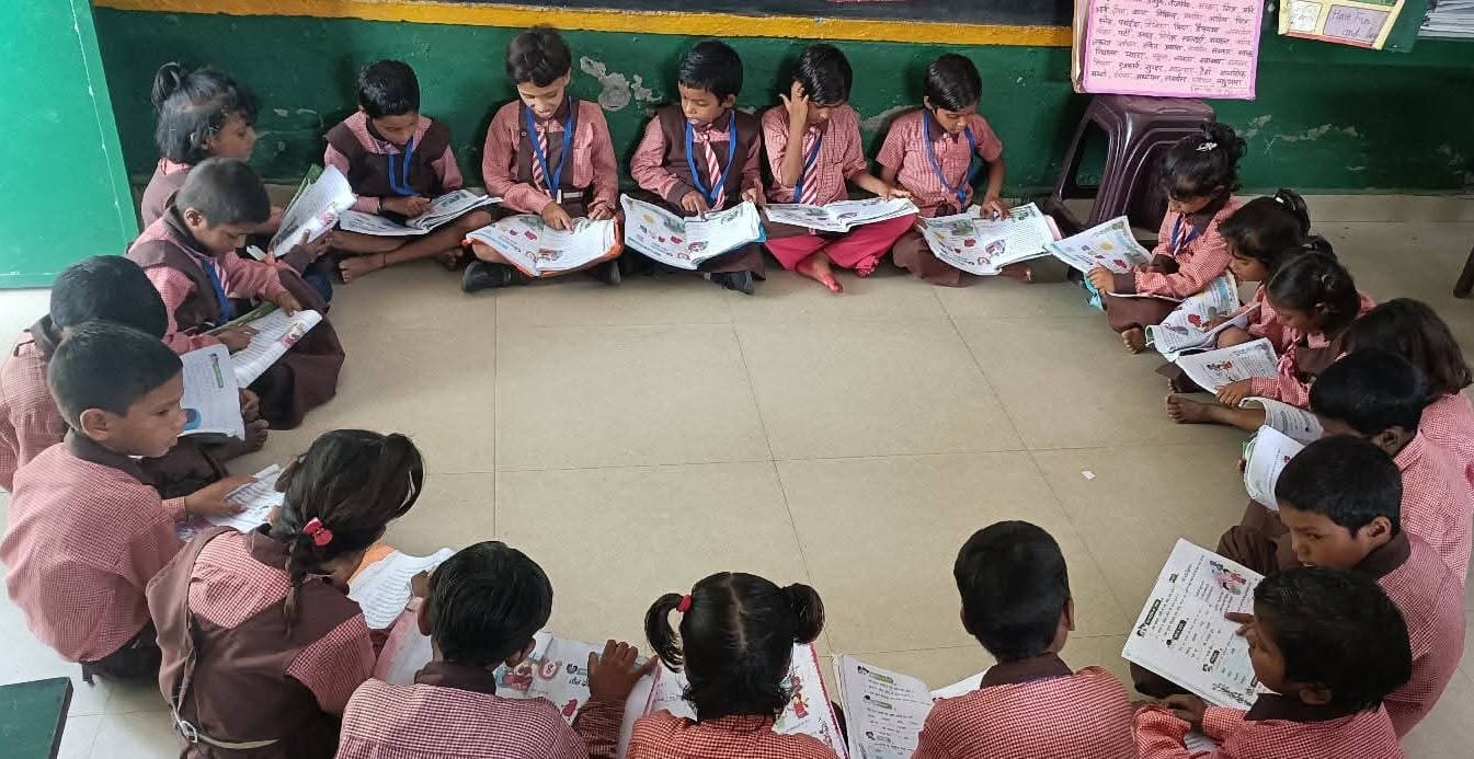 प्राथमिक  विद्यालय में किताब पढ़ते बच्चे। स्रोत स्कूल