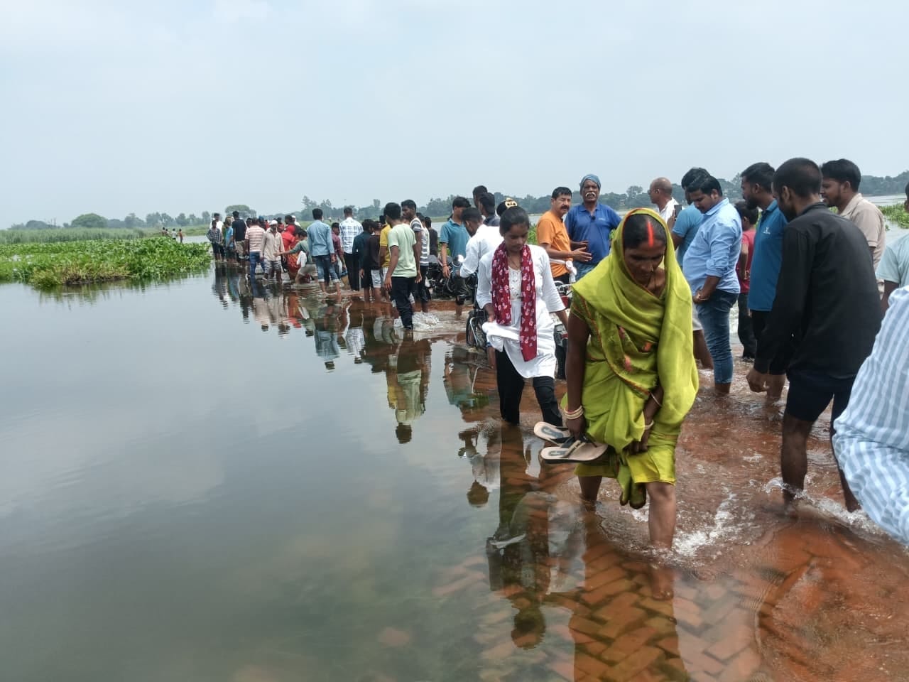 बेलहिया-अजगरा मार्ग बहने से नदी की तेज धारा में पार करते ग्रामीण। संवाद