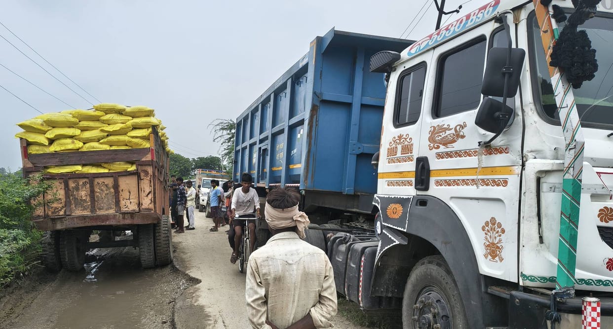 On the eight-foot-wide road, seized vehicles are on the right, and a broken-down tractor is on the left.