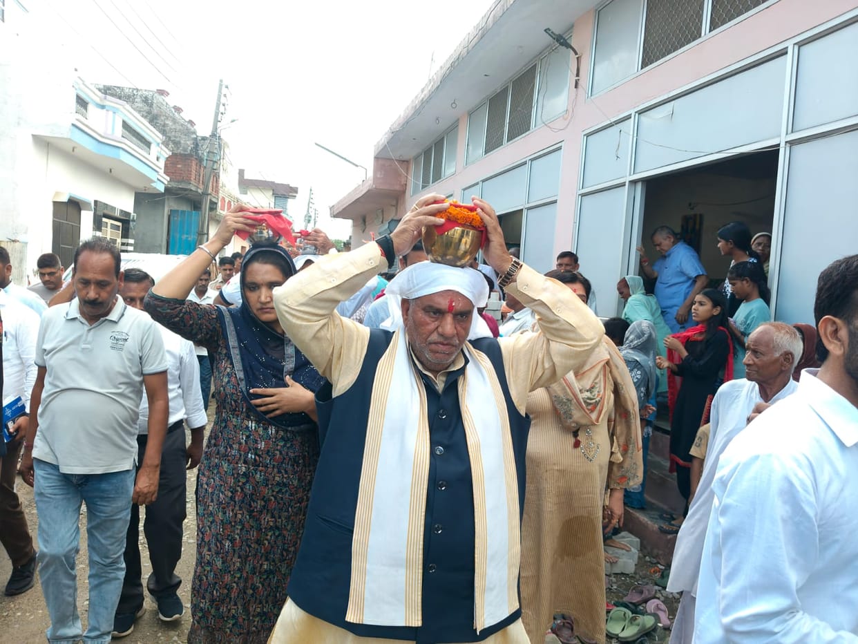 Minister arrives in Gadhauli village carrying a kalash on his head