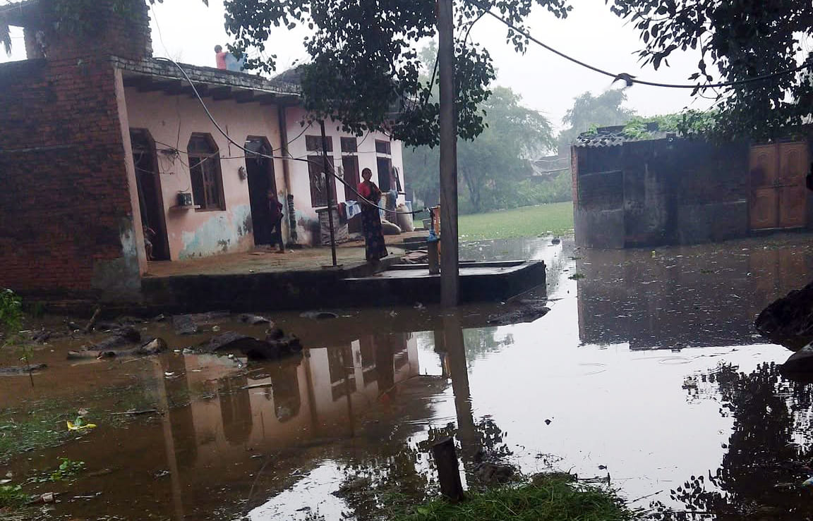 Ponds overflowed due to rain; water inundated paths, houses, and fields.