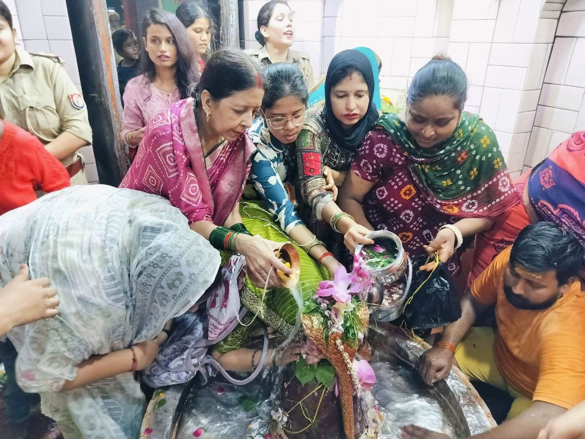 बहराइच के सिद्धनाथ मंदिर में सावन माह के सोमवार पर जलाभिषेक करतीं श्रद्धालु।